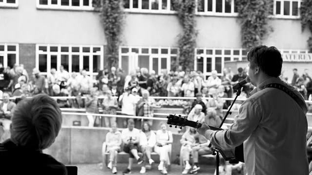 Hendrik Thiel spielt von der Bühne aus für ein Publikum im Freien